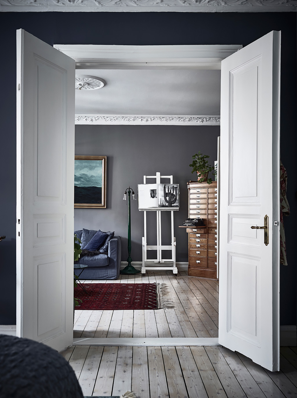 bohemian artist home scandinavian apartment  with houseplants wall art fireplace blue walls