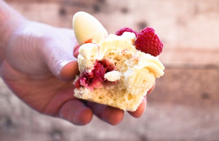 The inside of a raspberry and white chocolate cupcake held up to the camera