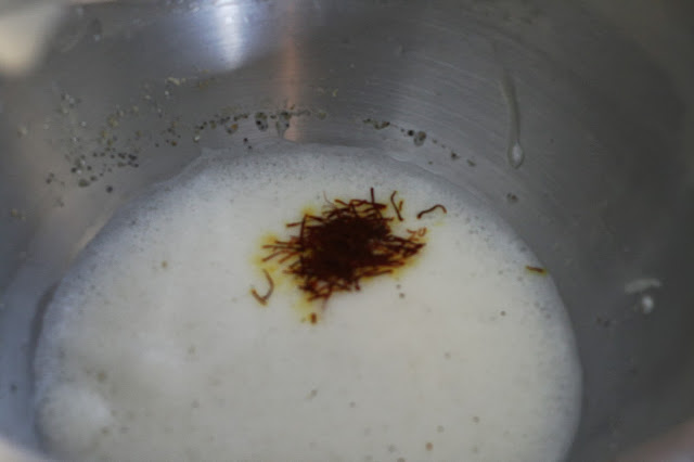 Threads of Saffron on top of whisked eggs in a mixing bowl.