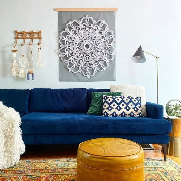 quilled round paper doily hanging on wall over couch