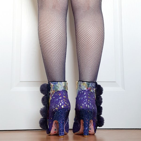 back view wearing fishnet tights and blue glitter heel ankle boots with pompom detail