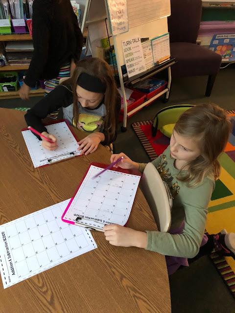 kids working on math problem with clipboards