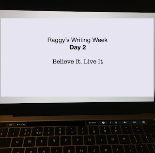 Laptop screen with text 'Raggy's Writing Week Day 2: Believe it. Live it'