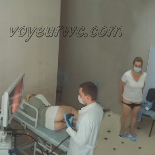 A patient lies on their side while a gastroenterologist inserts a colonoscope (Female colonoscopy SpyCam 01-05)