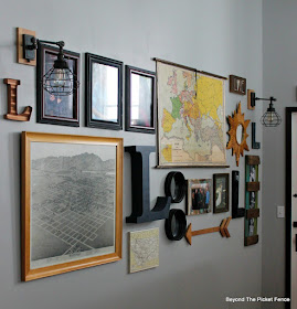 An eclectic gallery wall with old maps and marquee letters