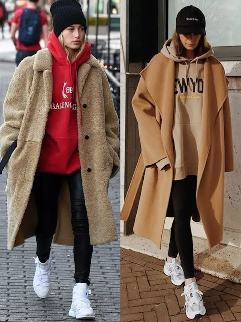A woman layers hoodie with coat.