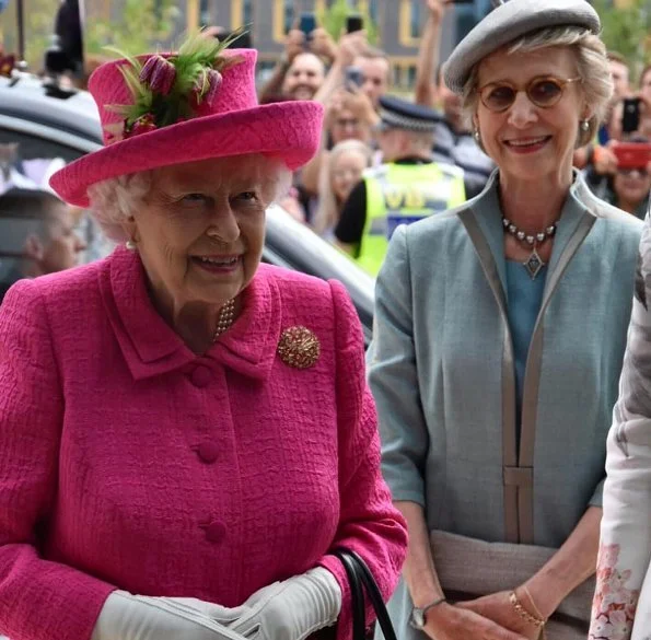 Queen Elizabeth wore a floral satin dress, pink coat and pink hat for visit National Institute of Agricultural Botany