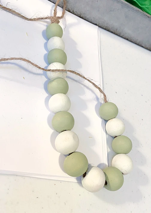 green and white painted beads on jute