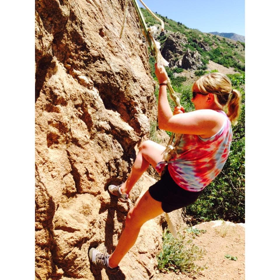an image of Frankie Ann using a rope to pull herself up on a mountain