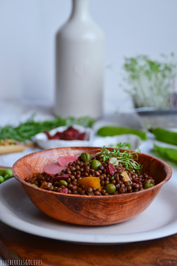 ENSALADA EN BOL DE BAMBÚ CON BROTES GERMINADOS Y ACEITERA CERÁMICA EN FONDO