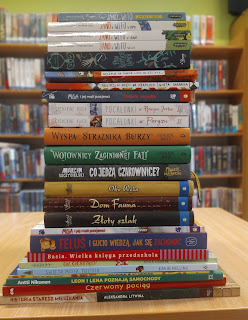 Stos książek ułożonych grzbietami. Książki leżą na stoliku
