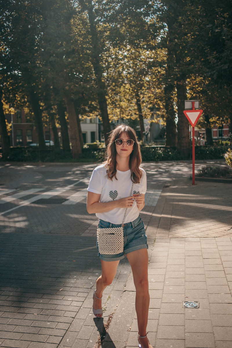 denim shorts, pearl handbag and white tee