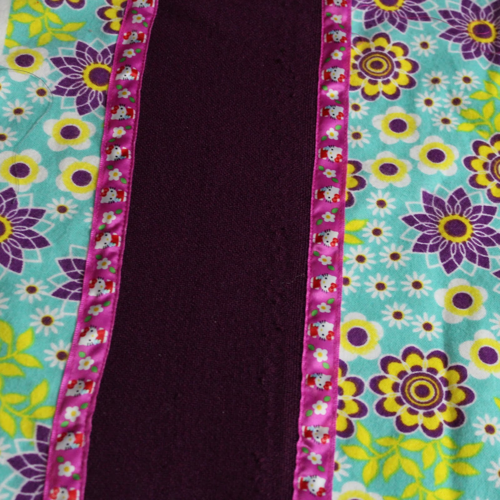 Sew the ribbon over the edges of contrasting panel. Make sure you cover