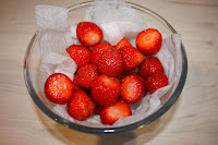 A bowl full of perfectly formed whole strawberries