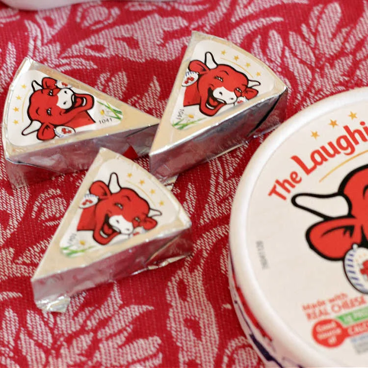 Laughing Cow Cheese Wedges on a red background