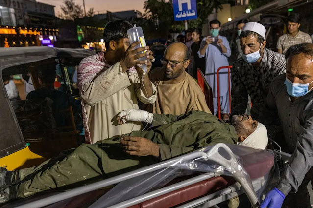 A man injured in the explosion is treated just outside the Kabul hotel. Photo: New York Times