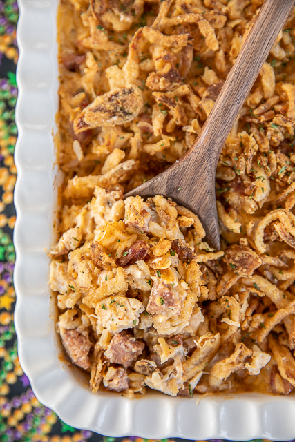 Cajun Dirty Rice Casserole - dirty rice loaded with chicken, smoked sausage, and parmesan cheese. SO good and SUPER easy to make! Zatarain's Dirty Rice, sour cream, cream of chicken soup, parmesan cheese, cooked chicken, smoked sausage, and french fried onions. Can make in advance and refrigerate or freeze for later. A great dish for your Mardi Gras parties! #cajun #mardigras #casserole #rice #freezermeal #chicken #smokedsausage dirty rice casserole in baking dish