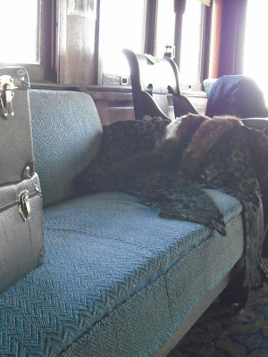 Image of chairs with luggage and fur coats.