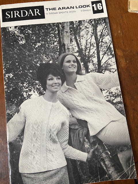 A black-and-white pattern showing two ladies in Aran cardigans.