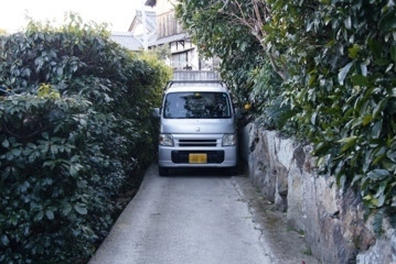 (ある島国で) 住宅地の細道を占領する大型車！