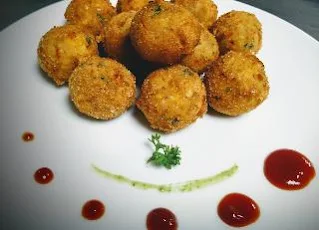 Garnished Corn cheese balls serving with sauce