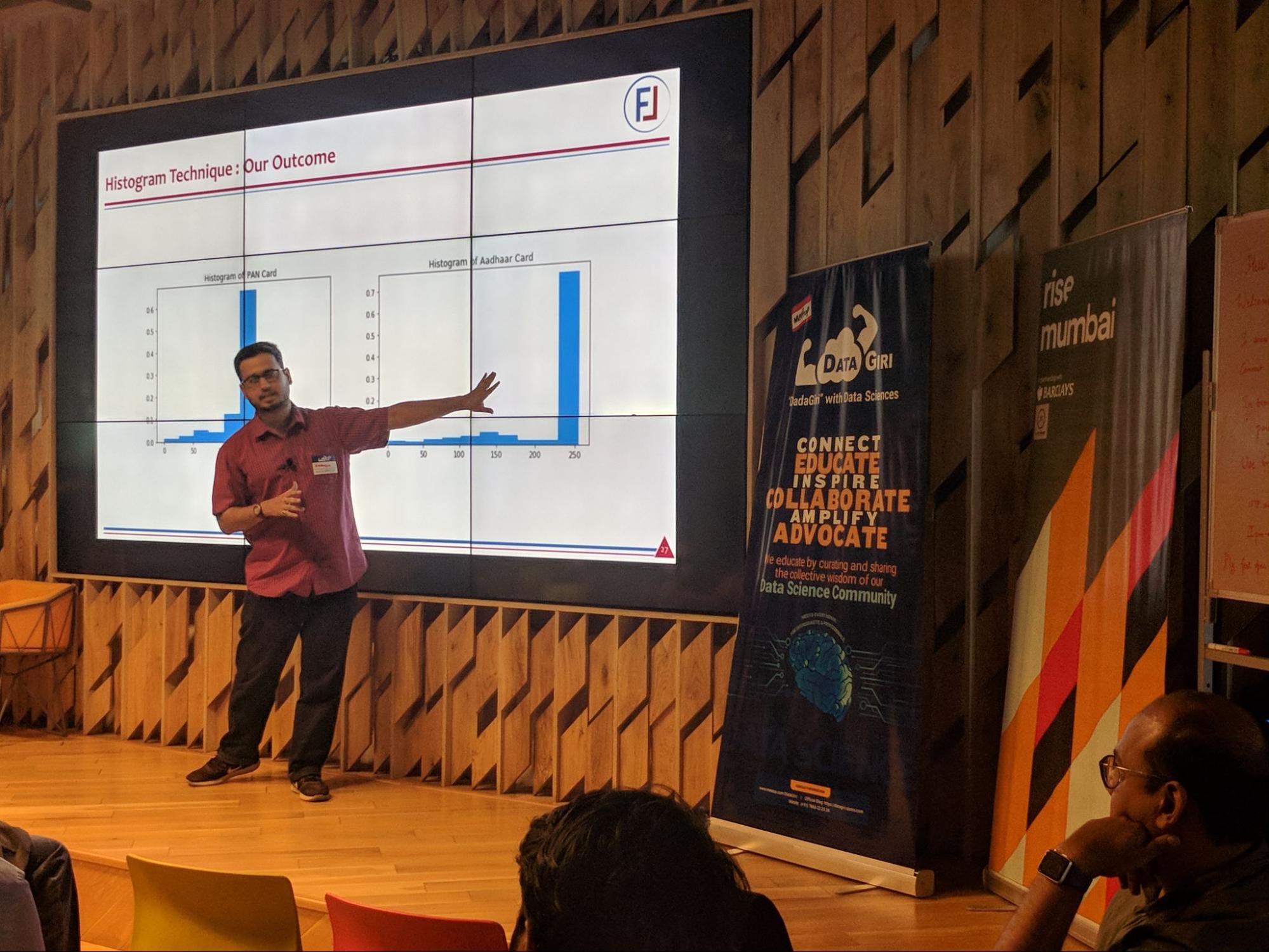 Image shows Bhavesh Bhatt onstage giving a presentation