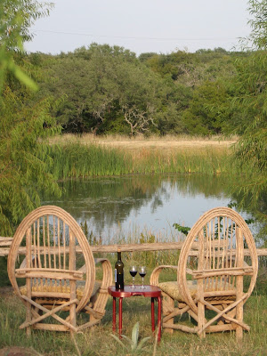 chairs by the pond with wine on a table