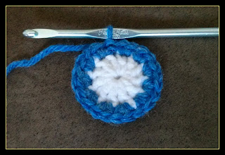 Pictured is the second round of single crochet stitches which form the face of the watch.  The first round is white double crochet, while the second is blue single crochet.