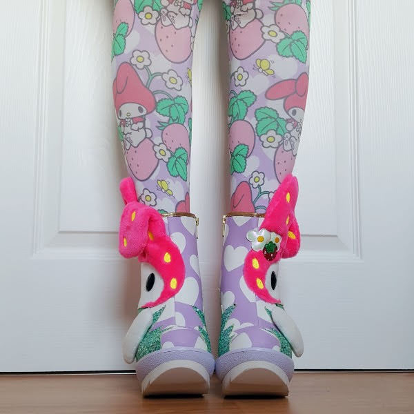 front of legs wearing lilac heart print ankle boots with Sanrio character applique