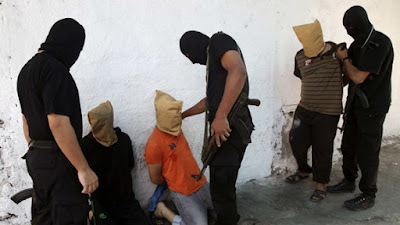 Hamas members prepare to execute Palestinians for allegedly spying for Israel in August 2014.