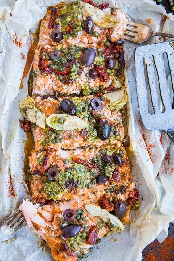 Mediterranean-inspired Salmon in Parchment Paper (or fish en papillote) with sun-dried tomatoes, kalamata olives, dill, capers, and artichoke hearts. This easy dinner recipe is paleo, keto, and packed with flavor!