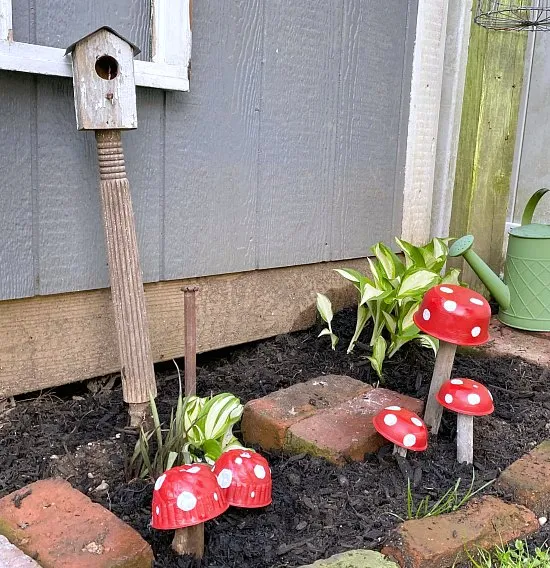 Repurposed Garden mushrooms in garden with birdhouse