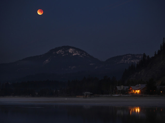 Gerhana Matahari - The moon casts a reddish hue over Lake Pend Oreille during a lunar eclipse as it begins to set behind the Selkirk Mountain Range near Sandpoint, Idaho December Inilah Foto-Foto Gerhana Matahari Yang Indah Dan Menakjubkan