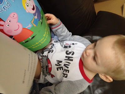 Blake in his PJ's reading his copy of Penwizard personalised story book - Peppa pig comes to your child's birthday party