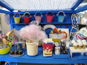 Details of the stock on a one-twelfth scale seaside stall, including toffee apples, candy floss, pop corn and ice creams.