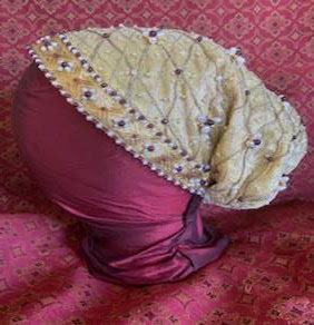 A gold silk goldhaub, decorated with small garnet and pearl beads