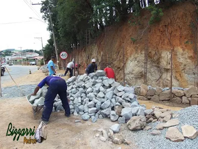 Execução do muro de pedra rústica tipo pedra moledo na face da frente do muro e no enchimento com pedra rachão sendo muro de pedra com junta seca sem massa nas juntas.