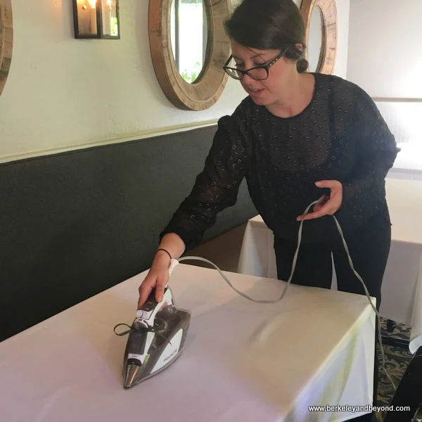 employee ironing tablecloth at The Farmhouse Inn restaurant in Forestville, California