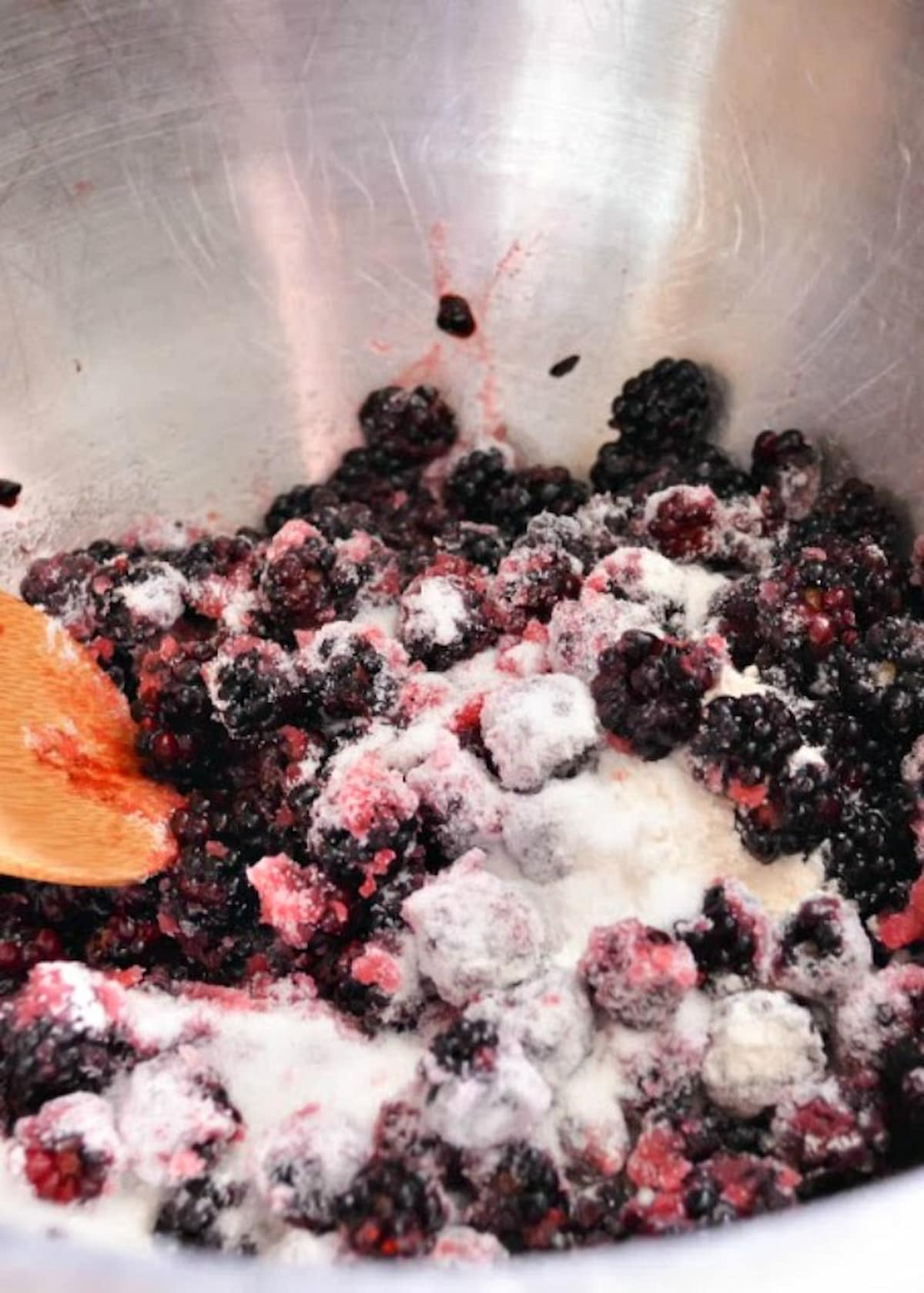 Blackberries, Sugar, and Flour in a mixing bowl for Blackberry Cobbler.