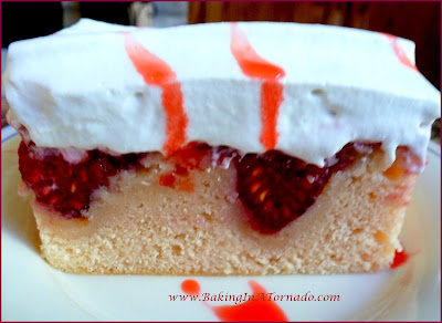 Berry Sangria Cake: A moist delicious sheet cake studded with fresh berries, topped with a berry wine sauce and topped with a whipped topping | Recipe developed by www.BakingInATornado.com | #recipe #cake #dessert