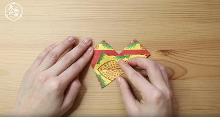 喪禮往生鞋子基本摺法:把下方的尖角,往上翻摺,突出約三角形 1/3 的高度