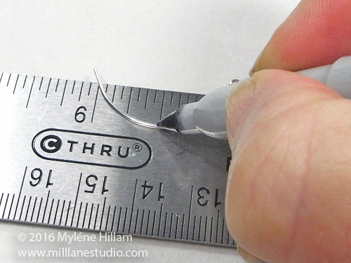 Marking the bend line on the curved eye pin with a permanent marker