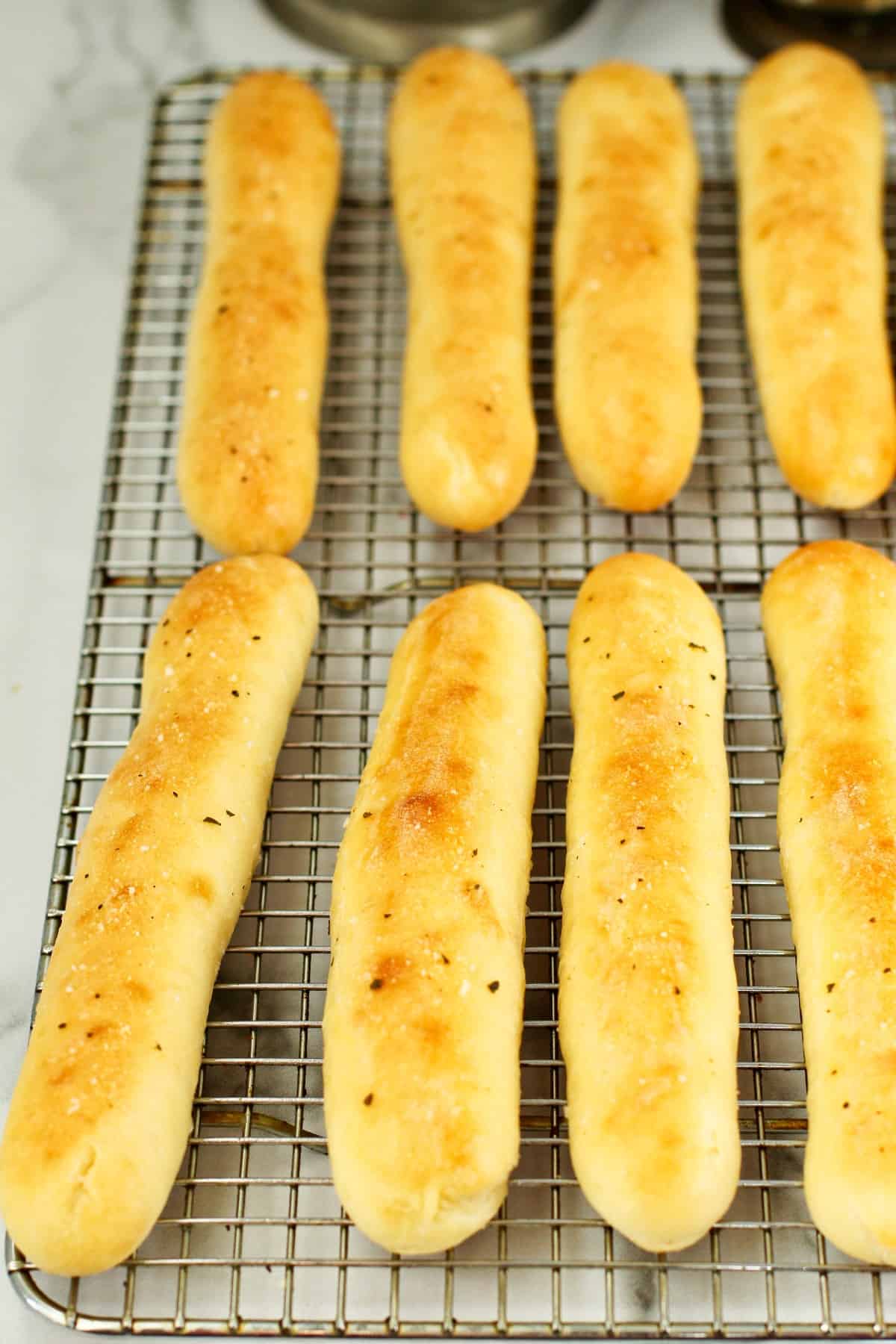 Olive Garden Copycat breadsticks cooling on a rack