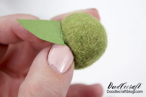 Press the ear on the green felted ball.