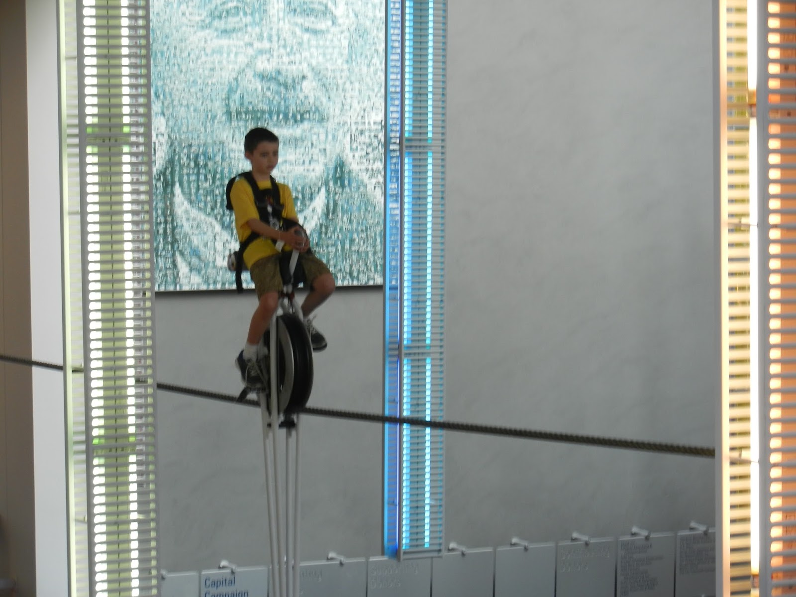 beauty of everyday life COSI stuck on the unicycle over the lobby