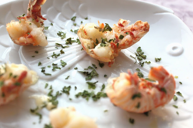 how to clean and cook rock shrimp these are on a white plate and butterflied with herb sauce