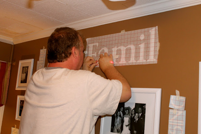 A man standing in front of a television playing a video game