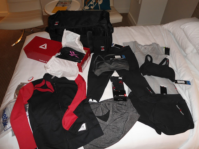 pile of brand new workout gear laying on a bed at the 2012 Reebok CrossFit Games 