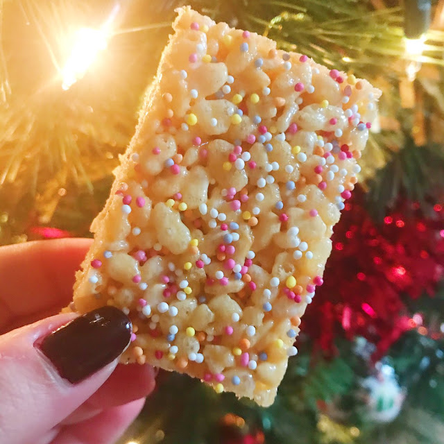 marshmallow treat held up in front of christmas tree