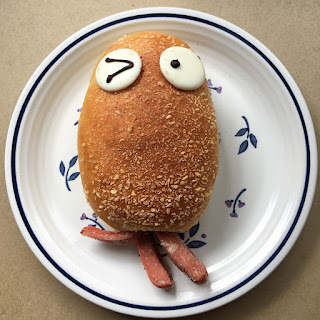 A bun with eyes and sausage that looks like an octopus